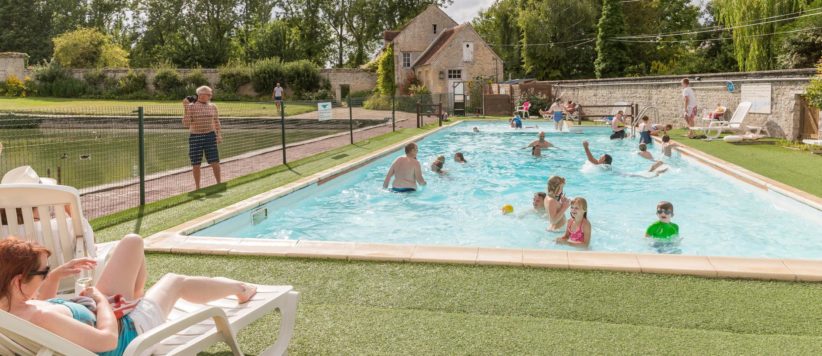 Rustige 4 sterren familiecamping in Normandië met zwembad, groene kampeerplaatsen in het park van een kasteel.